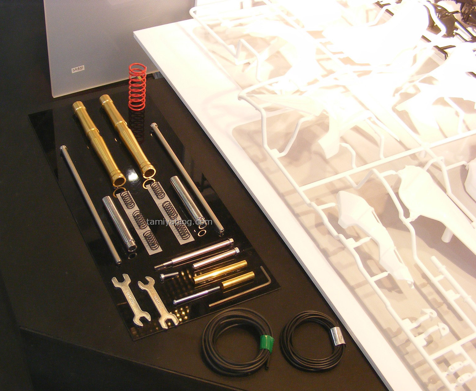  前避震器內有彈簧，所以組裝完成後可以實際壓縮，左下方的兩個小板手是供組裝時使用，一旁的空心塑膠管為煞車油管。