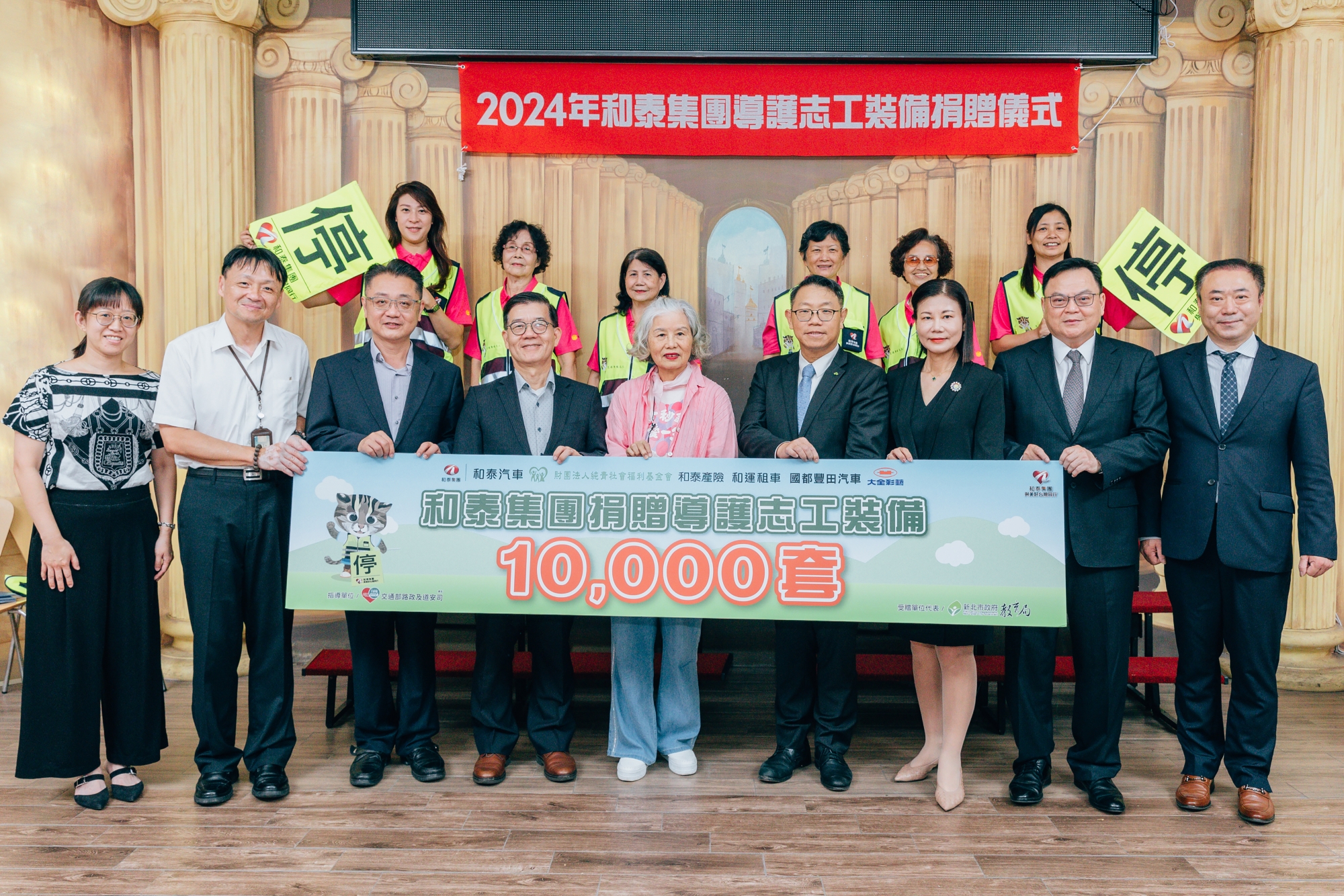 和泰集團2024年共捐贈全台國中小學一萬套導護志工裝備。前排左起：江翠國小家長會長劉必慧、校長柯志賢、新北市教育局副局長劉明超、交通部道安司司長黃運貴、和泰純青基金會執行長張琛惠、和泰汽車管理本部本部長賴志偉、和泰產險財務暨行政處副總顏承真、和運租車管理本部執行副總涂德義、國都汽車TOYOTA營業本部副總柯文彬