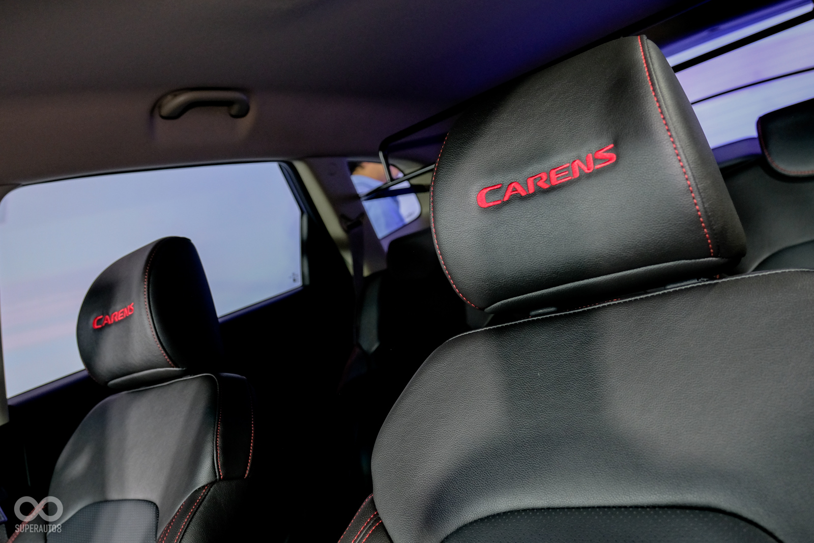 車內皮椅全以紅色縫線包覆，頭枕上方有著專屬的Carens字樣