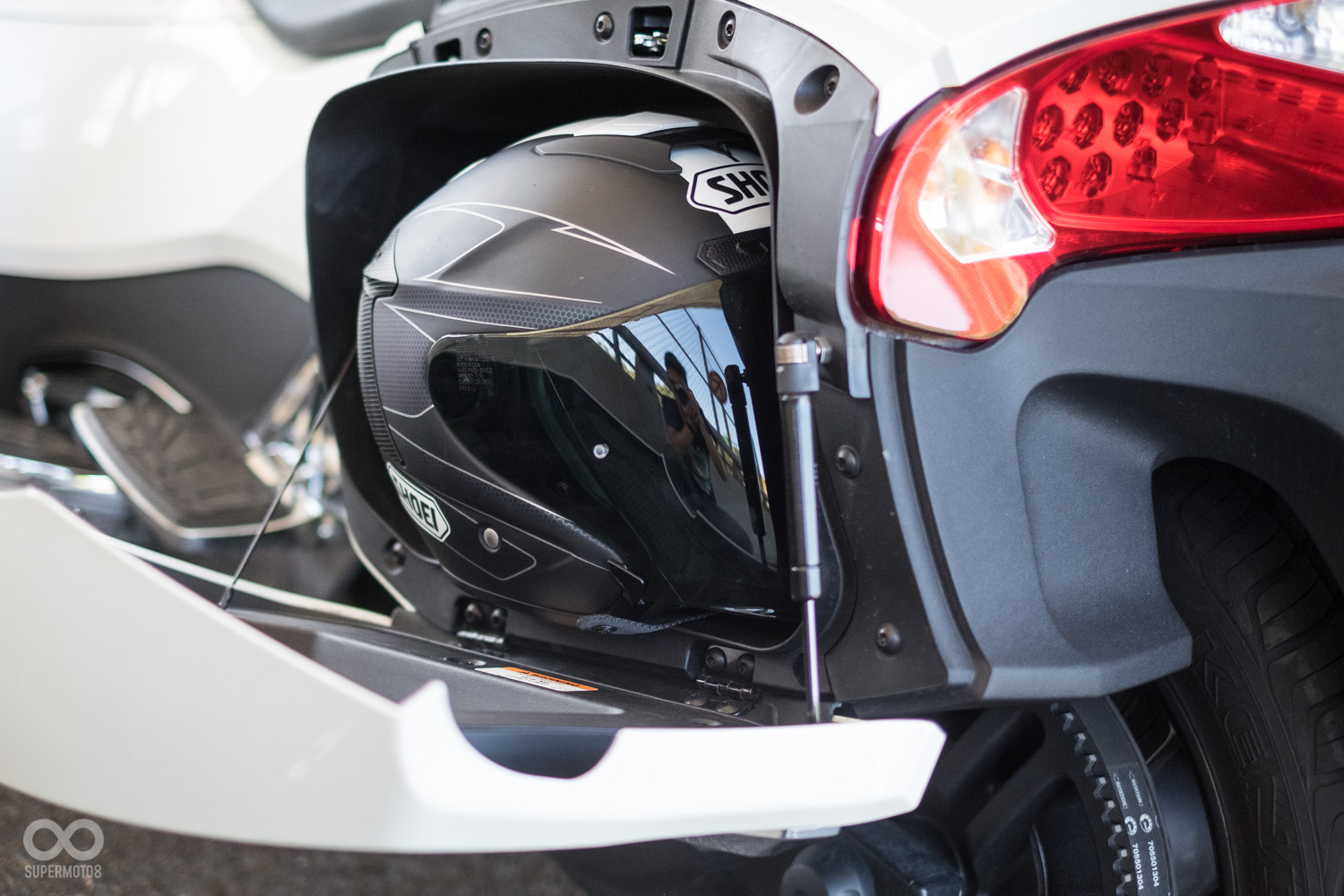 原廠宣稱側箱也能放入全罩安全帽，但實際測試只能放入小帽體的3/4