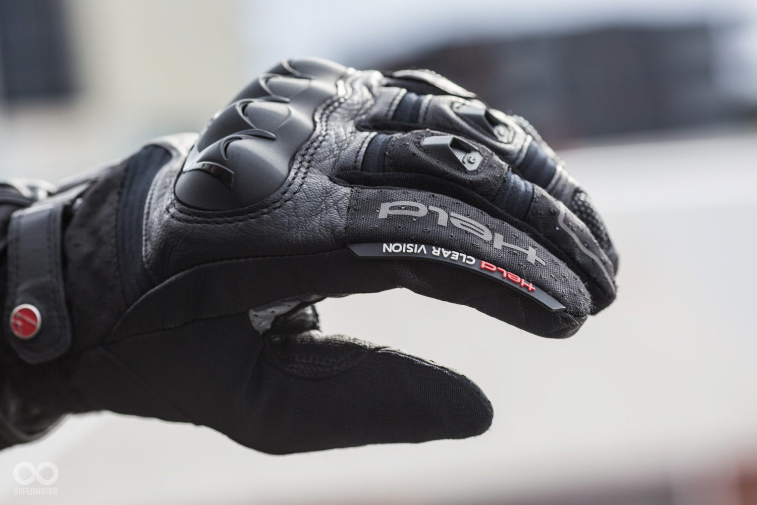 在左手的食指部分有一枚塑膠刮片，讓騎士在騎車時能撥去風鏡上的水珠